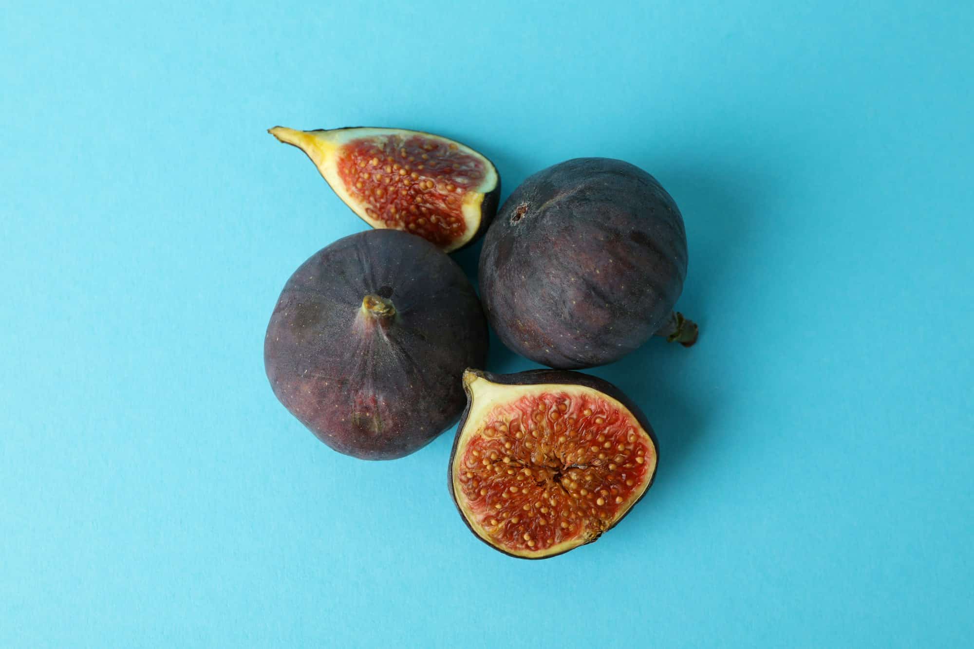 Ripe fig on blue background, close up