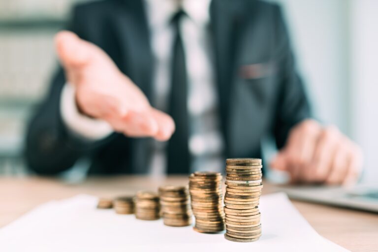 Banker offering financial loan, closeup of white collar business person in office with stacked coins